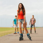 group of smiling teenagers with roller-skates